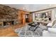 Inviting living room boasts a stone fireplace, hardwood floors, and large windows for ample natural light at 730 Crescent Ln, Lakewood, CO 80214