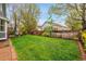 Beautifully landscaped backyard with a lush green lawn, flower beds, and a wooden fence at 1101 Ridgeview Cir, Broomfield, CO 80020