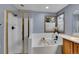 Well-lit bathroom showcasing a tiled shower and corner tub beneath a window at 1101 Ridgeview Cir, Broomfield, CO 80020