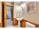 Cozy half bathroom featuring a pedestal sink, wood-paneled walls, and modern fixtures at 1101 Ridgeview Cir, Broomfield, CO 80020