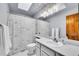 Bright bathroom featuring a white vanity, modern lighting fixture, and a shower with a decorative shower curtain at 1101 Ridgeview Cir, Broomfield, CO 80020