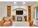 Inviting living room with a stone fireplace, custom built-in bookshelves, and stylish decor, creating a warm ambiance at 1101 Ridgeview Cir, Broomfield, CO 80020