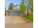 Lovely home featuring a three-car garage, gray siding, brick accents, and mature landscaping for enhanced curb appeal at 1101 Ridgeview Cir, Broomfield, CO 80020