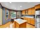 Corner kitchen featuring an island, stainless steel appliances, and oak cabinets at 1101 Ridgeview Cir, Broomfield, CO 80020