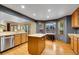 Bright kitchen with oak cabinets, central island, stainless steel appliances, and bay windows at 1101 Ridgeview Cir, Broomfield, CO 80020
