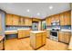 Spacious kitchen featuring an island, stainless steel appliances, and oak cabinets at 1101 Ridgeview Cir, Broomfield, CO 80020