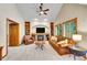Cozy living room with vaulted ceilings, a stone fireplace, built-in bookshelves, and comfortable leather furniture at 1101 Ridgeview Cir, Broomfield, CO 80020