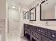 Bathroom featuring dual vanities with dark cabinets, marble countertops, and tile flooring at 800 Pearl St # 204, Denver, CO 80203
