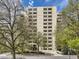 Exterior of a tall, beige brick apartment building with many balconies and mature trees surrounding it at 800 Pearl St # 204, Denver, CO 80203