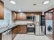 Bright kitchen featuring stainless steel appliances, wooden cabinets, and tile flooring at 800 Pearl St # 204, Denver, CO 80203
