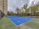 Outdoor tennis court with a new net surrounded by green landscaping and tall buildings at 800 Pearl St # 204, Denver, CO 80203