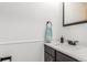 Powder bathroom features a modern black faucet, white countertop, and a clean design with wainscoting at 8736 E Easter Ave, Centennial, CO 80112