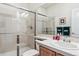 Clean bathroom with a glass-enclosed shower, tiled walls, and a single sink vanity with ample counter space at 1015 Graland Pl, Highlands Ranch, CO 80126