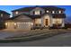 Charming two-story home with a three-car garage and a welcoming front porch, set against a twilight sky at 1015 Graland Pl, Highlands Ranch, CO 80126