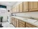 Well-lit laundry room featuring a white washer and dryer, ample wood cabinet storage, and a large white utility sink at 1015 Graland Pl, Highlands Ranch, CO 80126