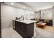 Basement kitchen with dark cabinetry and a modern island with seating at 1074 Knox Ct, Denver, CO 80204