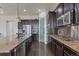 Modern kitchen with dark cabinetry and granite countertops at 21589 E Union Pl, Aurora, CO 80015