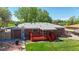 Aerial view of a home highlighting the backyard, red wood deck, patio area, and mature trees at 14157 E 26Th Ave, Aurora, CO 80011