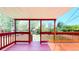 Outdoor deck offers a view of the backyard, framed by a red-painted railing and covered ceiling at 14157 E 26Th Ave, Aurora, CO 80011