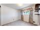 Cozy bedroom with neutral walls, soft carpeting, a window with decorative curtains, and custom shelving at 14157 E 26Th Ave, Aurora, CO 80011