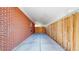 Carport made of red bricks and light colored concrete floor and ceiling and wood fence at 14157 E 26Th Ave, Aurora, CO 80011