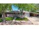Charming brick home featuring a manicured lawn, mature trees, and a cozy front porch at 14157 E 26Th Ave, Aurora, CO 80011