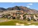Scenic aerial view of a golf course community with mountain backdrop, showcasing lush landscapes and luxury homes at 16611 Red Cliff Cir, Morrison, CO 80465