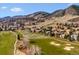 Breathtaking aerial view of a golf course community with homes nestled in a lush green landscape, with mountain views at 16611 Red Cliff Cir, Morrison, CO 80465