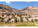 Panoramic aerial view of a residential area built into a mountainside with mature trees and breathtaking natural scenery at 16611 Red Cliff Cir, Morrison, CO 80465