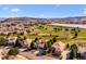 Aerial view of homes on the golf course community with lake and mountain views under a clear blue sky at 16611 Red Cliff Cir, Morrison, CO 80465