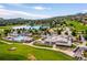 Beautiful aerial view of community amenities including a pool, lake, clubhouse, and golf course against a scenic mountain backdrop at 16611 Red Cliff Cir, Morrison, CO 80465