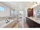 Bathroom featuring double sinks, glass-enclosed shower, and soaking tub at 16611 Red Cliff Cir, Morrison, CO 80465