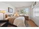 Well-lit bedroom with hardwood floors, a comfortable bed, and a view of the outdoors through a large window at 16611 Red Cliff Cir, Morrison, CO 80465