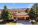 Charming home featuring a three-car garage, tile roof, mature trees, and manicured landscaping at 16611 Red Cliff Cir, Morrison, CO 80465