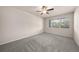 Bright bedroom with neutral carpet, ceiling fan, and large window with views at 9397 Las Ramblas Ct # D, Parker, CO 80134