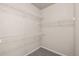 Walk-in closet featuring white wire shelving and neutral carpeting at 9397 Las Ramblas Ct # D, Parker, CO 80134