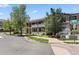 Two-story condo building with manicured lawn and mature trees under a blue sky at 9397 Las Ramblas Ct # D, Parker, CO 80134