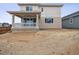New construction home featuring a covered patio with white railing and partially landscaped backyard at 45910 Gentry Ave, Bennett, CO 80102