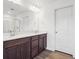 Bathroom with a double sink vanity, a large mirror, and wood-look flooring at 45910 Gentry Ave, Bennett, CO 80102