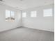 Bright bedroom with plush gray carpet and multiple windows at 45910 Gentry Ave, Bennett, CO 80102