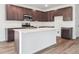 Modern kitchen with stainless steel appliances, dark cabinets, and a white center island at 45910 Gentry Ave, Bennett, CO 80102