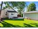 Spacious backyard with lush green grass, a detached garage, and an outdoor dining area, perfect for entertaining at 5543 S Prince St, Littleton, CO 80120