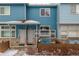 Two-story townhome with light blue siding, covered entry, and small fenced yard at 12035 Leyden St, Brighton, CO 80602