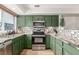 Modern kitchen with green cabinets and granite countertops at 12035 Leyden St, Brighton, CO 80602