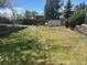 A large grassy backyard featuring a storage shed and split rail fence at 3961 S Uravan St, Aurora, CO 80013