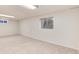 Unfinished basement with carpet, two windows, and white walls offers potential for customization at 3961 S Uravan St, Aurora, CO 80013