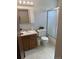 A half bath with a single sink vanity, lighting, and a standing shower at 3961 S Uravan St, Aurora, CO 80013