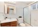 Bathroom with walk-in shower, wood vanity, and updated fixtures at 3961 S Uravan St, Aurora, CO 80013