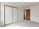 Spacious bedroom showcasing closet with sliding doors and doorway to another room at 3961 S Uravan St, Aurora, CO 80013