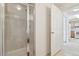 Bathroom featuring a tiled shower with glass door, modern fixtures, and access to the kitchen at 5800 Tower Rd # 1201, Denver, CO 80249